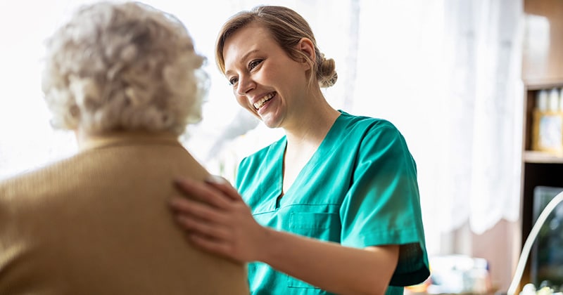 Doctor in scrubs tends to elderly patient